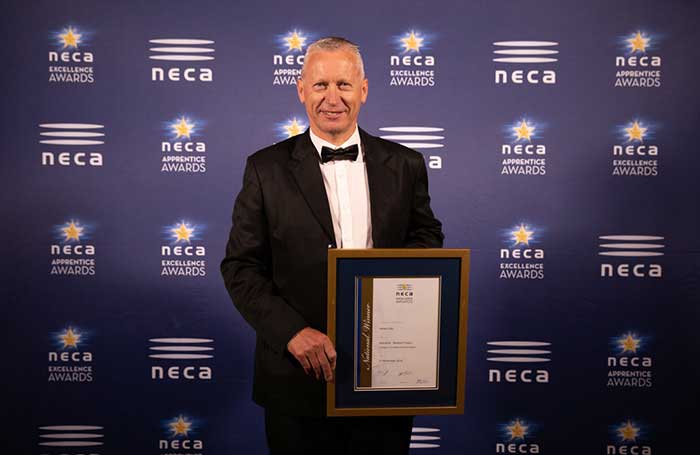 General Manager Richard Lane holds a award frame.